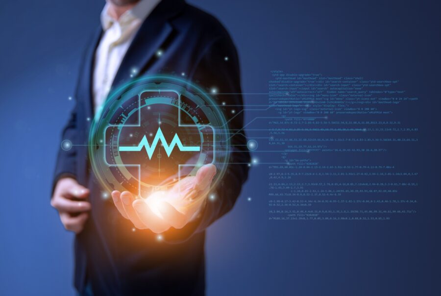 Close up of a man holding up an illustration of a heart monitor line within a medical cross