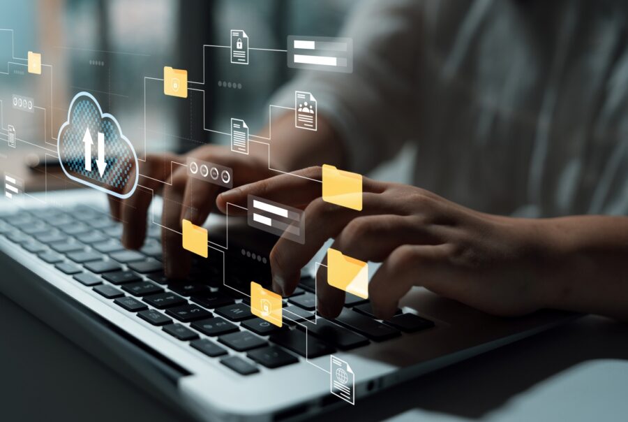 Close up of a person typing on a laptop keyboard, while illustrations of files hover above